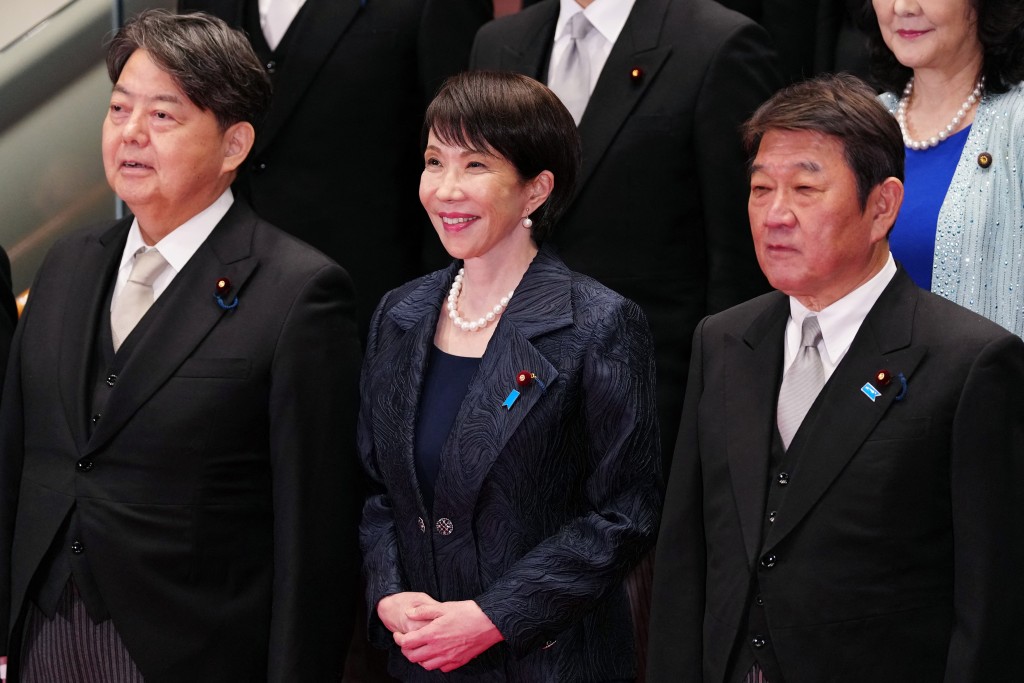 Japan's new Prime Minister Sanae Takaichi (C) poses during a photo session with members of her cabinet at the prime minister's office in Tokyo on October 21, 2025. (Photo by Jia Haocheng / POOL / AFP)