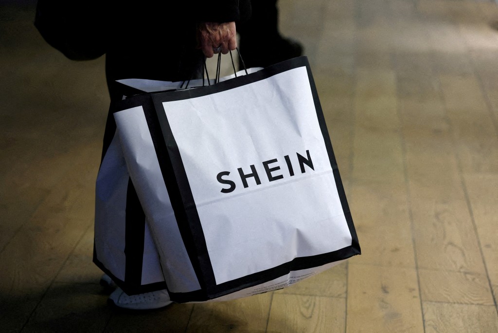 A customer holds shopping bags with a Shein logo in the first physical space of online fast-fashion retailer Shein on the day of its opening inside the Le BHV Marais department store, the Bazar de l'Hotel de Ville, in Paris, France, November 5, 2025. REUTERS