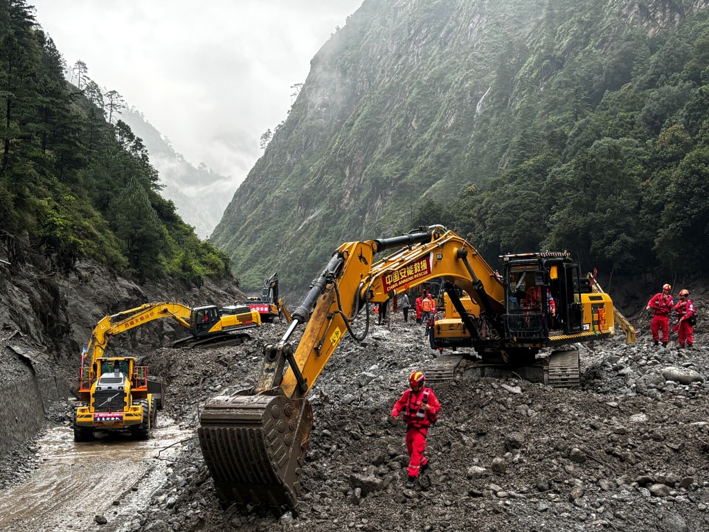 Rescue workers operate excavators and loaders to repair a damaged road leading to Gyirong Port following a mudslide, in Shigatse, Tibet Autonomous Region, China August 29, 2026. (Reuters)
