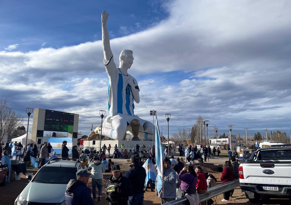 People gather by a statue of Argentina's revered Lionel Messi to watch the World Cup semi-final between Argentina and England, in Cutral Co, in the Patagonian province of Neuquen, Argentina, July 15, 2026. REUTERS/Leila Miller 