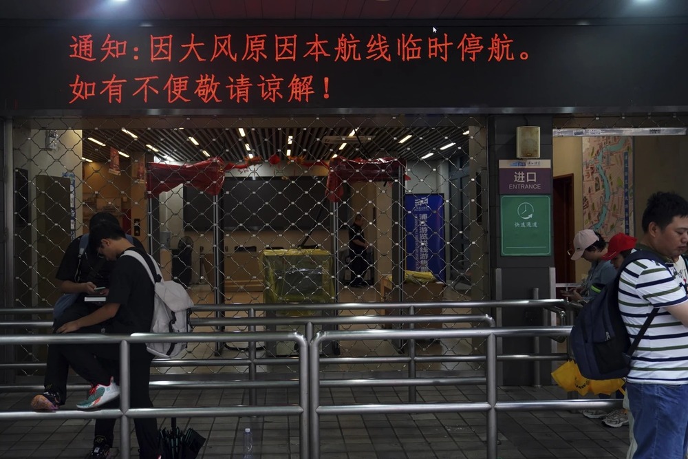 In this photo released by Xinhua News Agency, stranded passengers gather near a closed ferry ahead of the landfall of Typhoon Bebinca in Shanghai, China, Sunday, Sept. 15, 2024. (Chen Haoming/Xinhua via AP) 