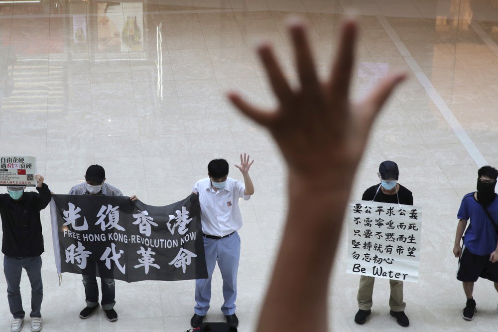 Protesters gesture with five fingers, signifying the 'Five demands - not one less' in a shopping mall. (AP photo) Protesters gesture with five fingers, signifying the 'Five demands - not one less' in a shopping mall. (AP photo)