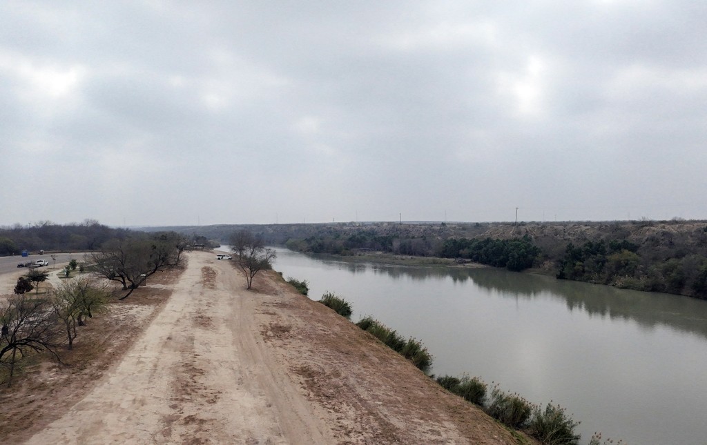 An aerial view shows a Border Patrol van parked by the Rio Grande River at Father M. McNaboe Park, where the US government plans to build a US-Mexico border wall, in Laredo, Texas, on February 20, 2026. (Photo by MOISES AVILA / AFP)