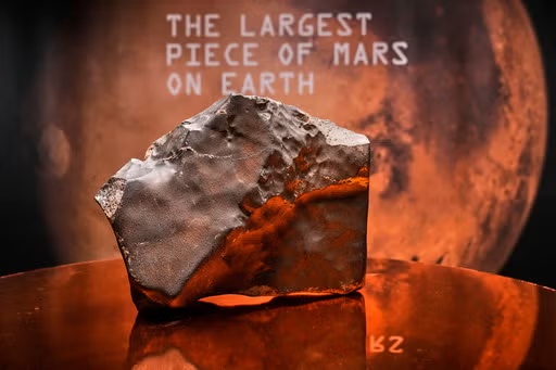 A Martian meteorite, weighing 54.388 lbs. (24.67 kg), said to be the largest piece of Mars on Earth, estimated at $2 - 4 million, is displayed at Sotheby's, in New York, Wednesday, July 9, 2025, part of their Geek Week auction, July 16, 2025. (AP Photo/Richard Drew)