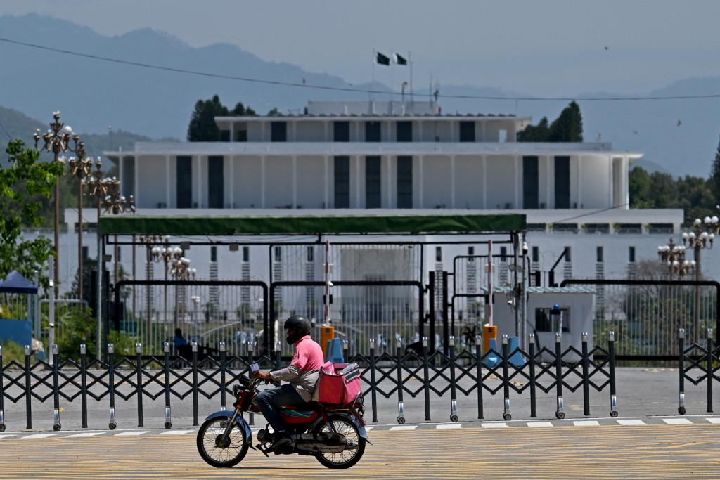 A rider for the delivery platform Foodpanda rides past the President House at the Red Zone area in Islamabad on April 26, 2026 after authorities lifted the heightened security and restrictions imposed in the area ahead of anticipated US-Iran peace talks. (AFP)