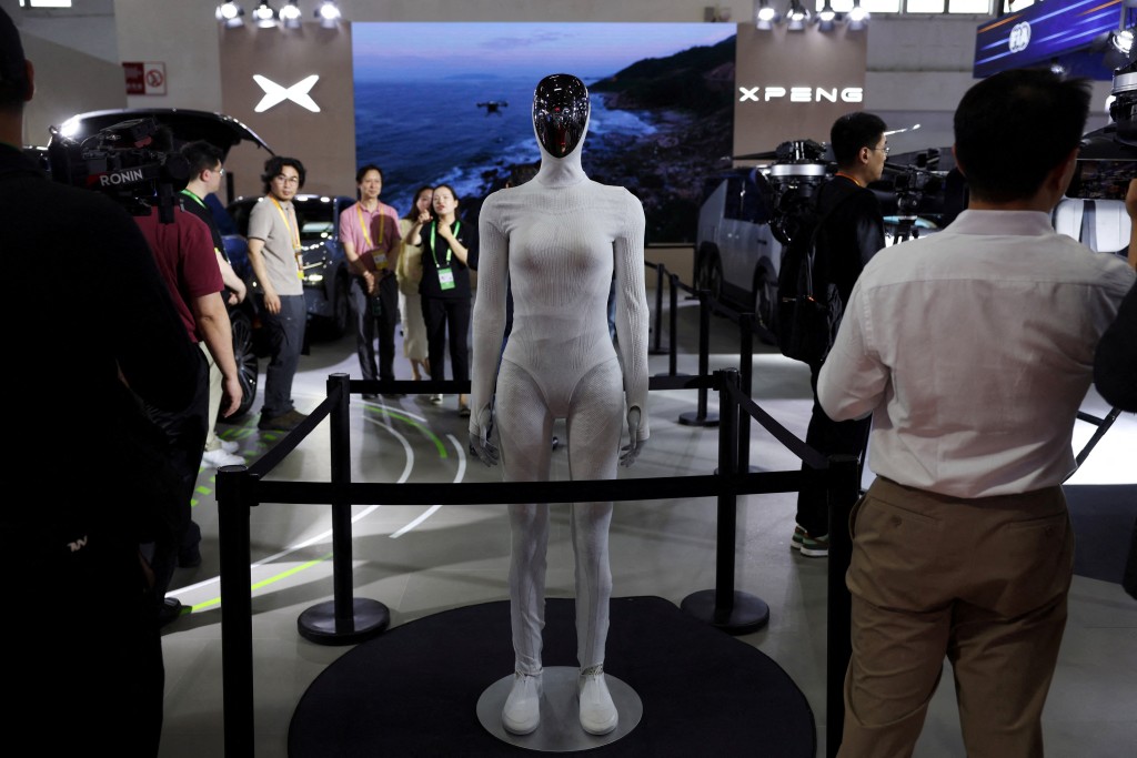 FILE PHOTO: People stand near an Xpeng IRON humanoid robot displayed at the electric vehicle maker's booth during the China International Supply Chain Expo (CISCE) in Beijing, China June 22, 2026. REUTERS/Florence Lo/File Photo