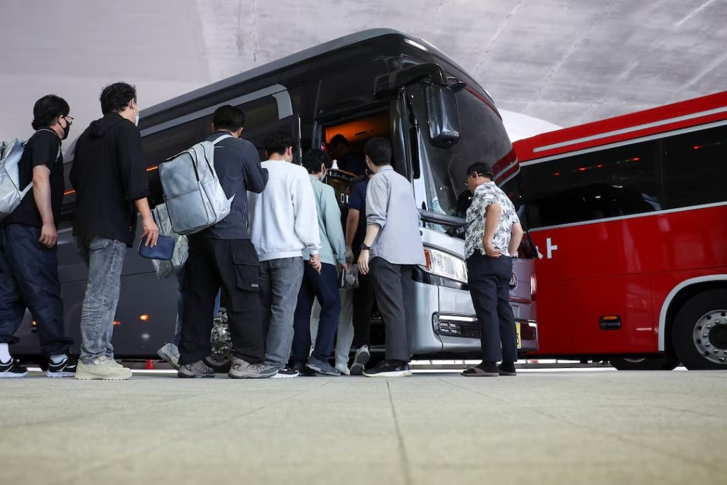 South Korean workers who were detained in a huge immigration raid last week at the site of a U.S. car battery project involving Hyundai Motor and LG Energy Solution in the U.S. state of Georgia, board a bus following their arrival at the Incheon International Airport in Incheon, South Korea, September 12, 2025. REUTERS/Kim Hong-ji 