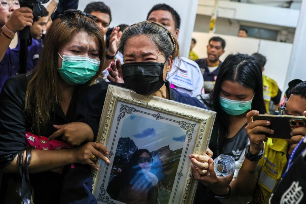 Family members react as they receive the body of a victim at the Police Hospital morgue, following a deadly fire at a pub in Bangkok, Thailand, July 14, 2026. REUTERS/Athit Perawongmetha