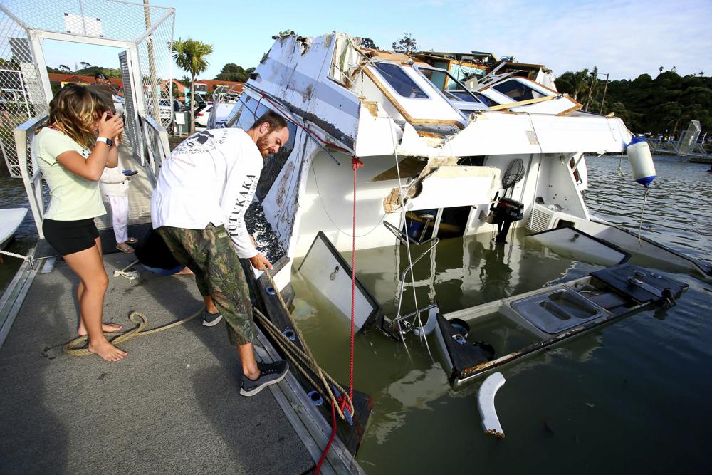 A couple look at a damaged boat in a marina at Tutukaka, New Zealand, Sunday, Jan. 16, 2022, after waves from a volcano eruption swept into the marina. AP A couple look at a damaged boat in a marina at Tutukaka, New Zealand, Sunday, Jan. 16, 2022, after waves from a volcano eruption swept into the marina. AP