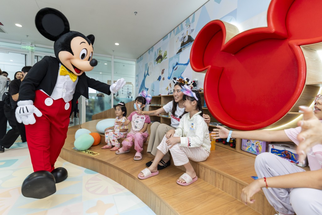 Mickey Mouse greets children at the caring space.