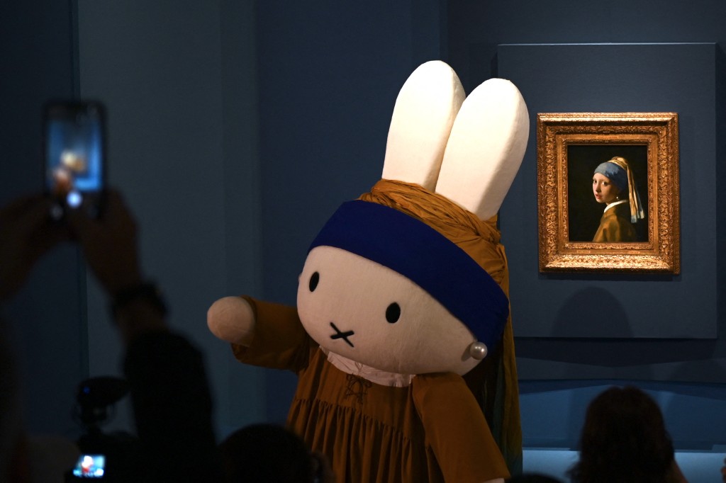 Visitors look at the 'Girl with a Pearl Earring' painting by Dutch artist Johannes Vermeer alongside the rabbit character Miffy created by Dutch artist Dick Bruna at Nakanoshima Museum of Art in Osaka on August 20, 2026. (Photo by Hiroshi Hiyama / AFP)
