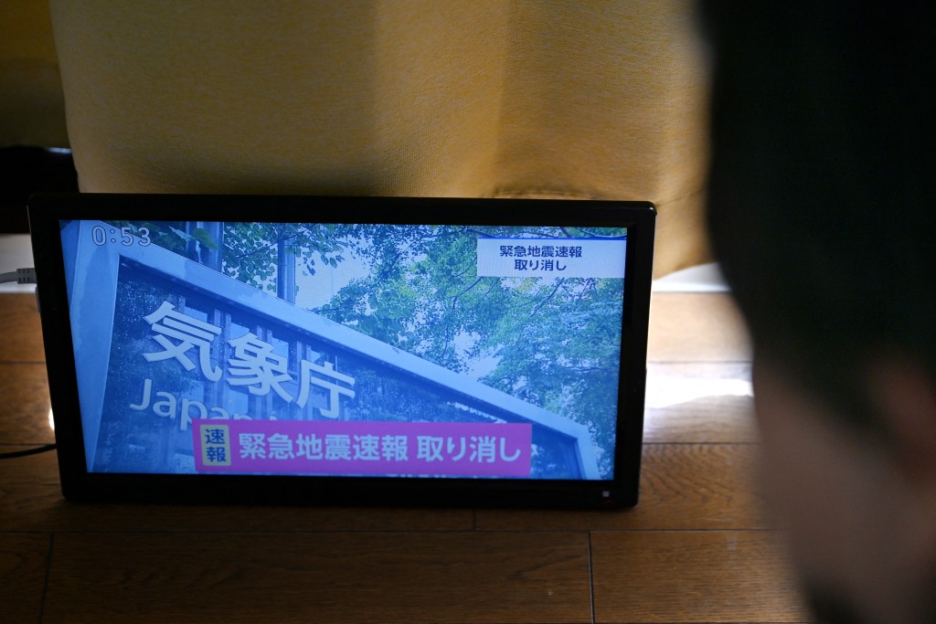 Photo by RIE KIKUCHI / AFP  An advisory that reads "Emergency Earthquake Alert Cancelled" is seen on a television screen in Tokyo on October 16, 2026.