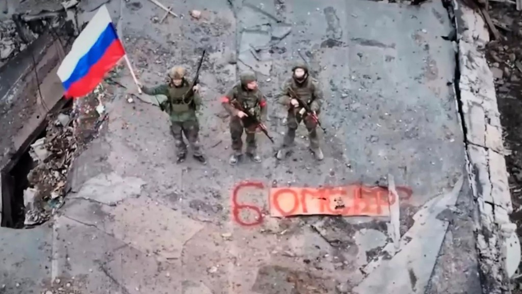 Russian soldiers hold a flag in Siversk, a city in the Donetsk region, Ukraine. AP