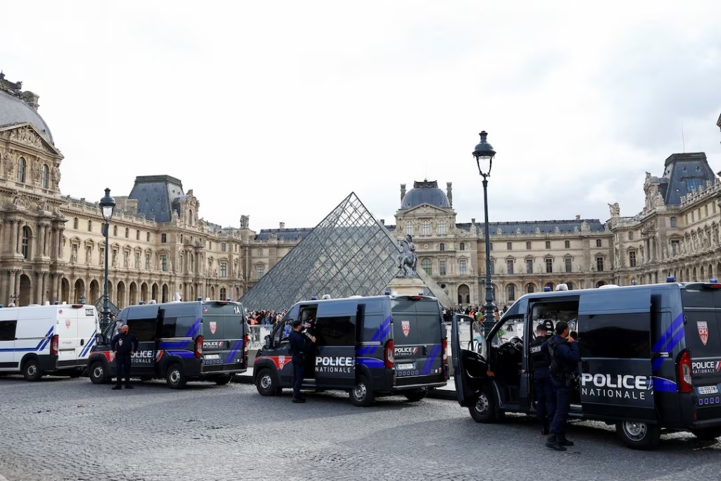 French police vans are parked near the glass Pyramid of the Louvre Museum, after French police arrested suspects in the Louvre heist case, in Paris, France October 27, 2025. REUTERS/Abdul Saboor