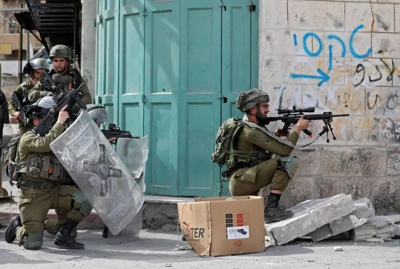 Israeli security forces amid clashes with Palestinian protesters in Hebron city, in the occupied West Bank, on April 1, 2021. (AFP) Israeli security forces amid clashes with Palestinian protesters in Hebron city, in the occupied West Bank, on April 1, 2021. (AFP)