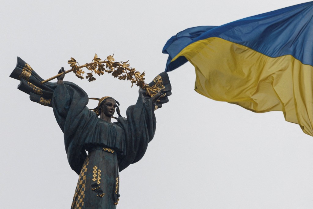 FILE PHOTO: A Ukrainian national flag waves in front of the Independence Monument, amid Russia's attack on Ukraine, in Kyiv, Ukraine November 26, 2025. REUTERS/Valentyn Ogirenko/File Photo