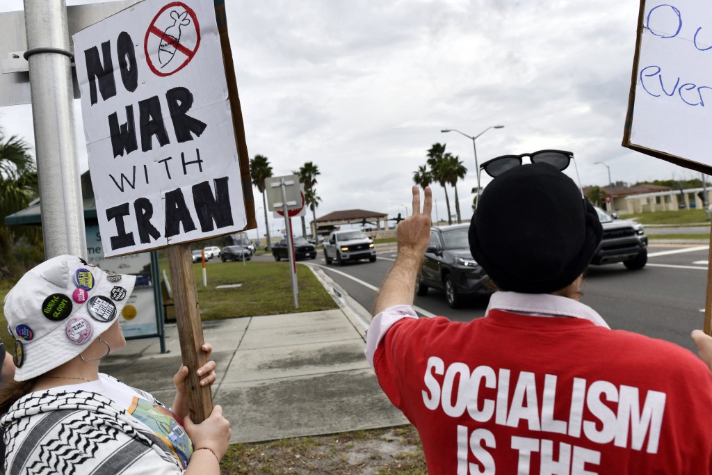 Demonstrators hold signs during a protest to call for "an end to the imperialist violence" amid the ongoing war in Iran outside MacDill Air Force Base, where US Central Command is headquartered, in Tampa, Florida, on March 12, 2026. (Photo by Octavio JONES / AFP)