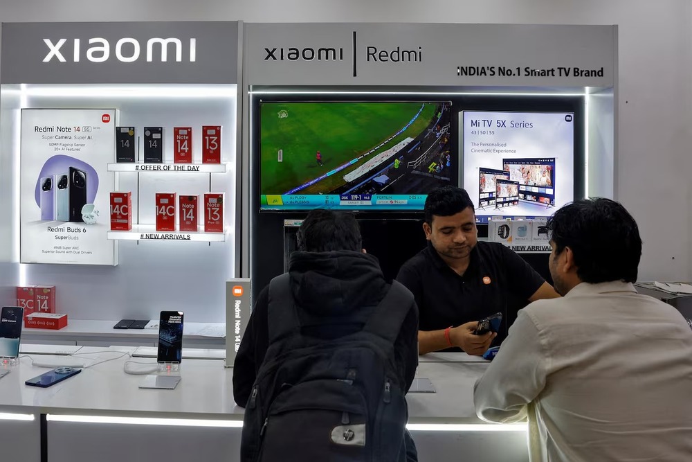 A salesperson shows a new Xiaomi mobile phone to customers at a store in New Delhi, India, February 1, 2025. REUTERS A salesperson shows a new Xiaomi mobile phone to customers at a store in New Delhi, India, February 1, 2025. REUTERS