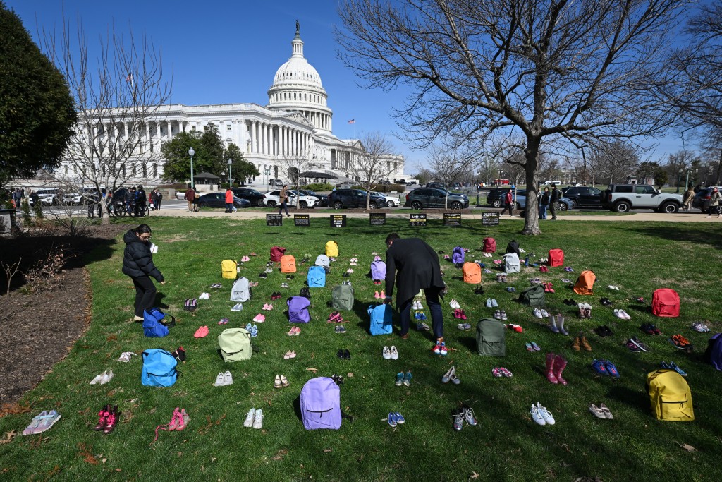 A memorial made up of shoes and backpacks symbolizing those killed in the bombing of the Minab elementary school and other civilians killed in Iran sits outside the United States Capitol on March 18, 2026 in Washington, DC. Democratic lawmakers spoke at a press conference in front of the memorial to cal for an end of the conflict in Iran. Matt McClain/Getty Images/AFP