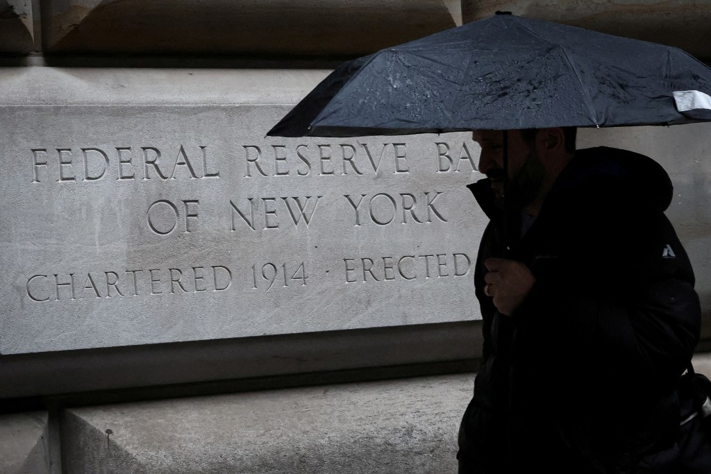 A man passes by the Federal Reserve Bank of New York in New York City, U.S., March 13, 2023. REUTERS