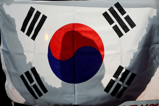 A person holds a South Korean flag in front of the National Assembly in Seoul, South Korea, December 6, 2024. (Reuters)
