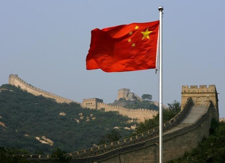 A Chinese flag flies in front of the Great Wall of China, located north of Beijing August 18, 2007. REUTERS/David Gray