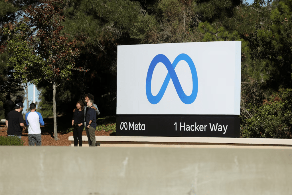 People pose for a photo in front of a sign of Meta, the new name for the company formerly known as Facebook, at its headquarters in Menlo Park, California, U.S. October 28, 2021. REUTERS/Nathan Frandino/File Photo