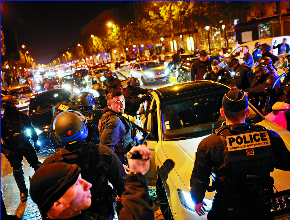 Police officers hold protesters against a vehicle. Reuters Police officers hold protesters against a vehicle. Reuters