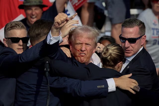 Republican presidential candidate and former U.S. President Donald Trump is assisted by the Secret Service after gunfire rang out during a campaign rally at the Butler Farm Show in Butler, Pennsylvania, U.S., July 13, 2024. REUTERS/Brendan McDermid/File Photo