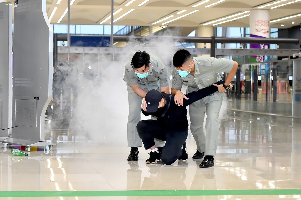 Customs officers subduing the attacker during the drill.