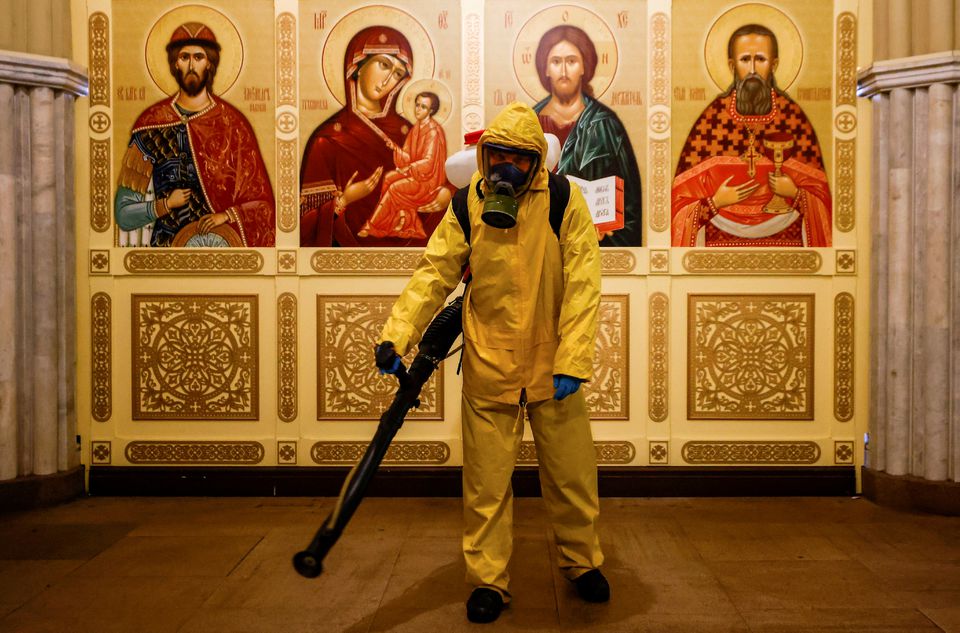 A specialist wearing personal protective equipment (PPE) sprays disinfectant while sanitizing a chapel inside the building of the Leningradsky railway station. (Reuters) A specialist wearing personal protective equipment (PPE) sprays disinfectant while sanitizing a chapel inside the building of the Leningradsky railway station. (Reuters)