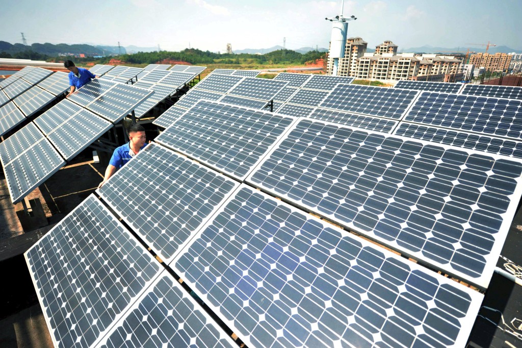 Workers install solar panels on the rooftop of a company in Shangrao, Jiangxi province, China, October 11, 2015.  REUTERS/Stringer 