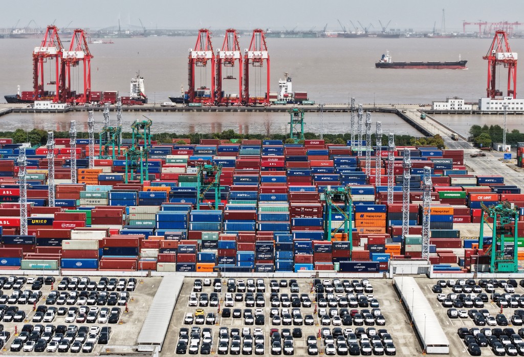 A drone view shows electric vehicles (EV) for export and containers sitting at a port in Shanghai, China April 13, 2025. China Daily via REUTERS ATTENTION EDITORS - THIS PICTURE WAS PROVIDED BY A THIRD PARTY. CHINA OUT. NO COMMERCIAL OR EDITORIAL SALES IN CHINA.