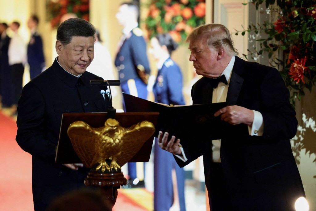 US President Donald Trump holds a binder as he stands next to Chinese President Xi Jinping before Xi delivers a speech during a state dinner at the White House in Washington, D.C., US, September 24, 2026. REUTERS/Evelyn Hockstein
