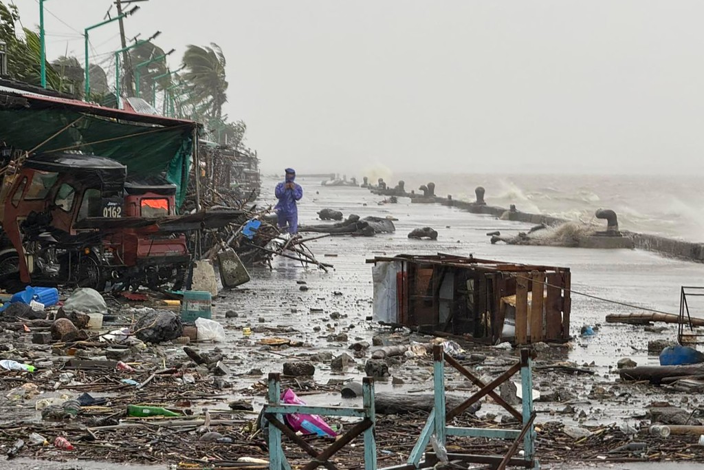 A man stands near debris on a waterfront road amid heavy rain due to weather patterns from Super Typhoon Ragasa in Aparri town, Cagayan province on September 22, 2025. (Reuters)