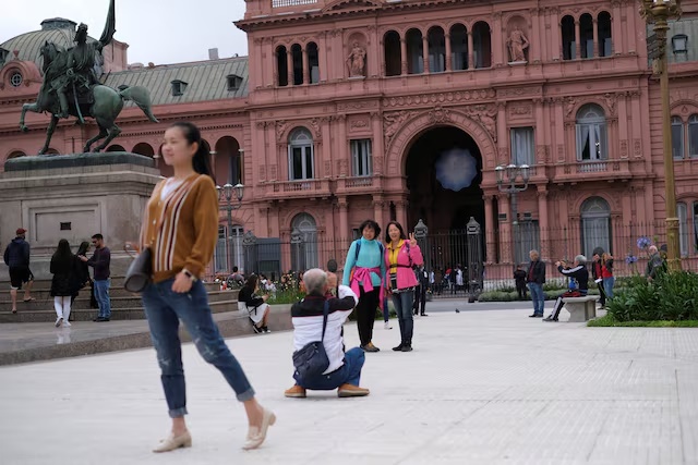 Tourist pose for pictures in front of the presidential palace Casa Rosada in Buenos Aires, Argentina October 29, 2019. REUTERS/Carlos Garcia Rawlins/File Photo