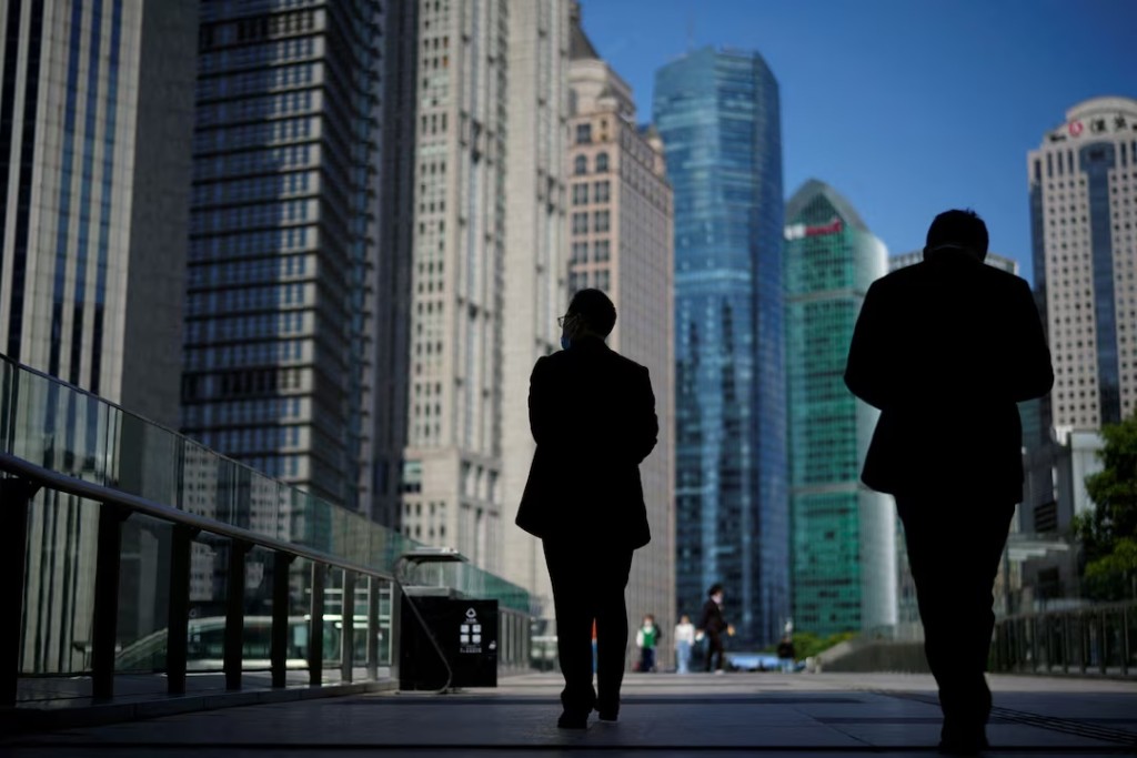 People walk by office towers in the Lujiazui financial district of Shanghai, China October 17, 2022. REUTERS/Aly Song/File Photo