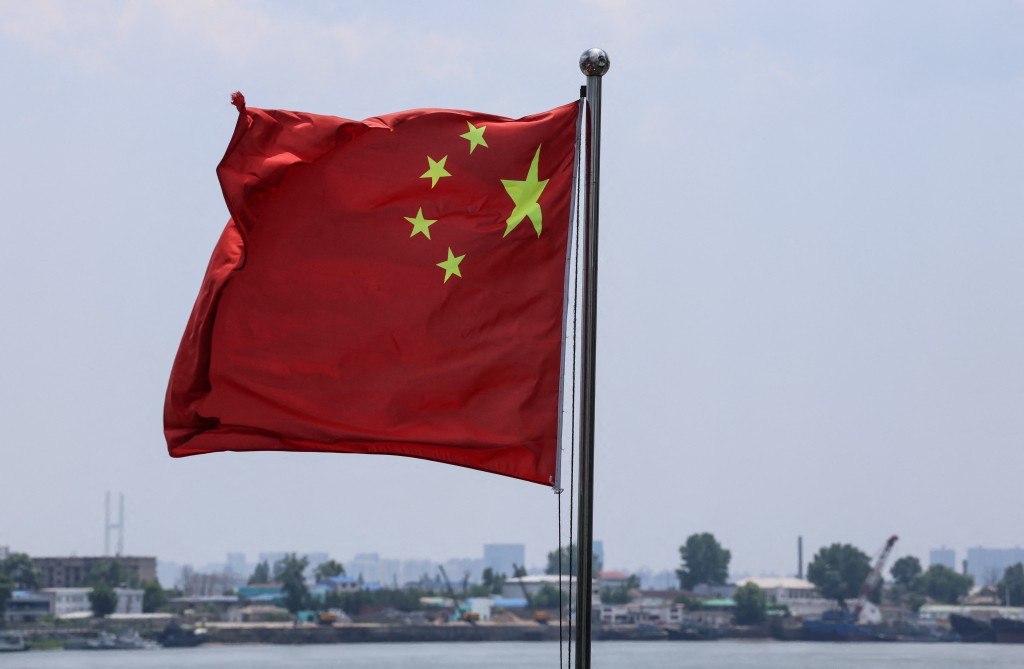 The Chinese national flag flies in the wind over the Yalu River, with buildings of the North Korean city of Sinuiju behind, on the bank across, in Dandong, Liaoning province, China, June 8, 2026. REUTERS/Maxim Shemetov