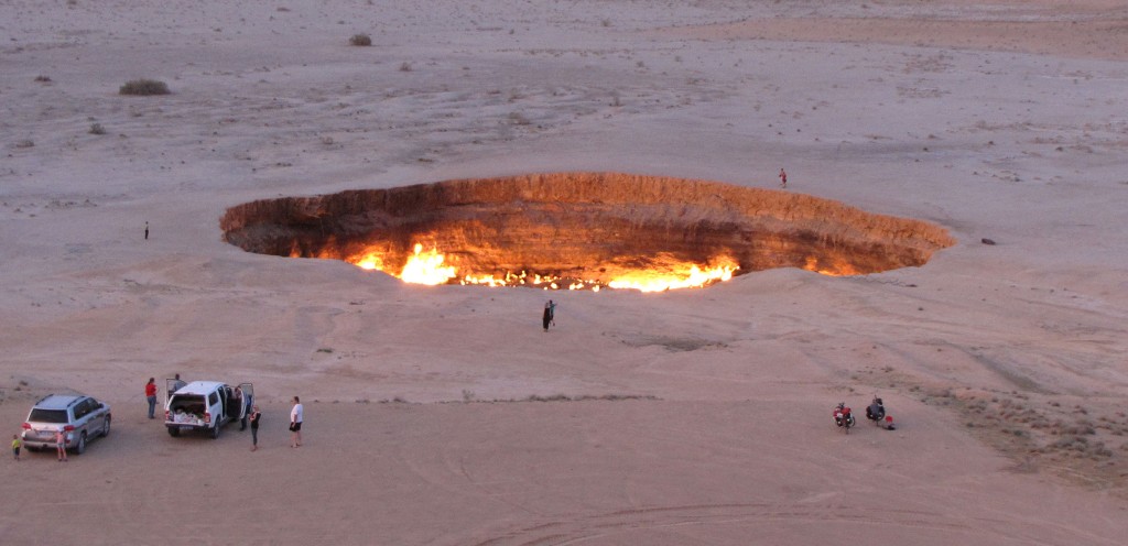 (FILES) A picture taken on May 3, 2014, shows people visiting "The Gateway to Hell," a huge burning gas crater in the heart of Turkmenistan's Karakum desert. (Photo by Igor SASIN / AFP)
