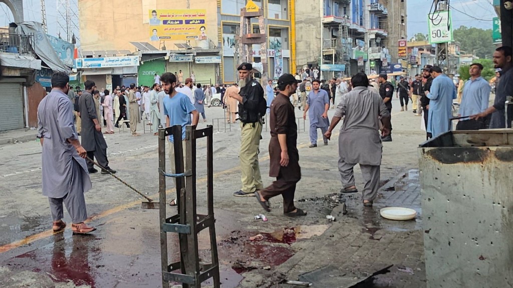 People clean after a suspected suicide bombing outside a police station. Reuters