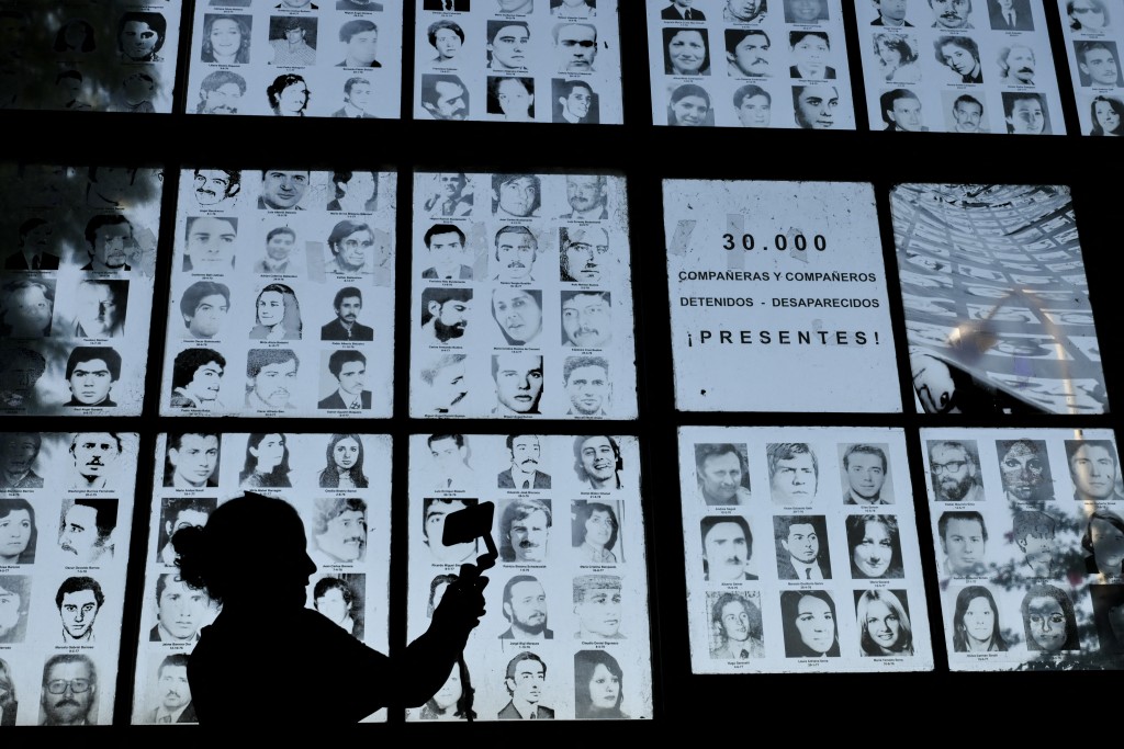 Photo by LUIS ROBAYO / AFP  Photos of people who disappeared during the Argentine dictatorship (1976-1983) are displayed at the former clandestine detention center of the Navy School (ESMA) in Buenos Aires on March 18, 2026.