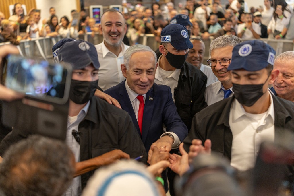 Photo by ILIA YEFIMOVICH / AFP  Israeli Prime Minister Benjamin Netanyahu stands amid security personnel as he meets with voters at a mall in Ramle on October 19, 2026.