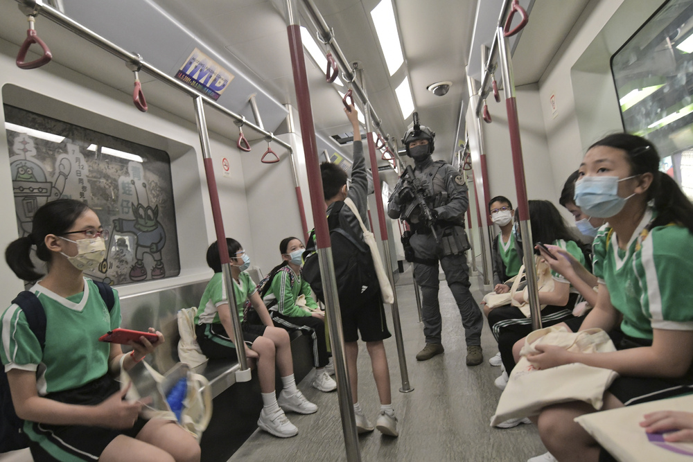 A railway response team member joins kids as officers march in goose-step. SING TAO, AFP