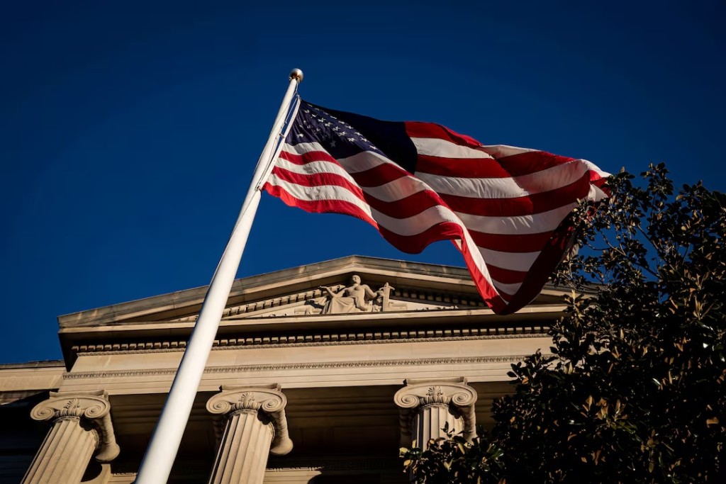 An American flag waves outside the U.S. Department of Justice Building in Washington, U.S., December 15, 2020. REUTERS/Al Drago/File Photo