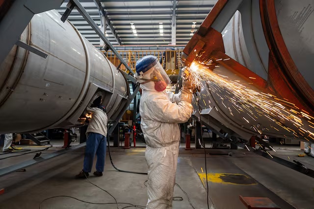 Workers work on a production line, manufacturing tank containers at a factory in Nantong, Jiangsu province, China April 7, 2025. cnsphoto via REUTERS