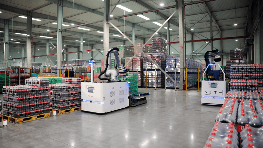 AI-powered picking robots operate among pallets of shrink-wrapped beverages at Swire Coca-Cola’s Zhengzhou plant, supporting the automated preparation of mixed-product orders. Swire Coca-Cola AI-powered picking robots operate among pallets of shrink-wrapped beverages at Swire Coca-Cola’s Zhengzhou plant, supporting the automated preparation of mixed-product orders. Swire Coca-Cola