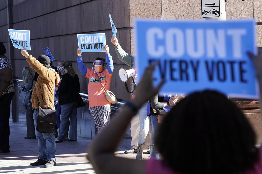 Demonstrators stand across the street from the federal courthouse in Houston, Texas, on Monday, before a hearing in federal court involving drive-thru ballots cast in Harris County. Demonstrators stand across the street from the federal courthouse in Houston, Texas, on Monday, before a hearing in federal court involving drive-thru ballots cast in Harris County.