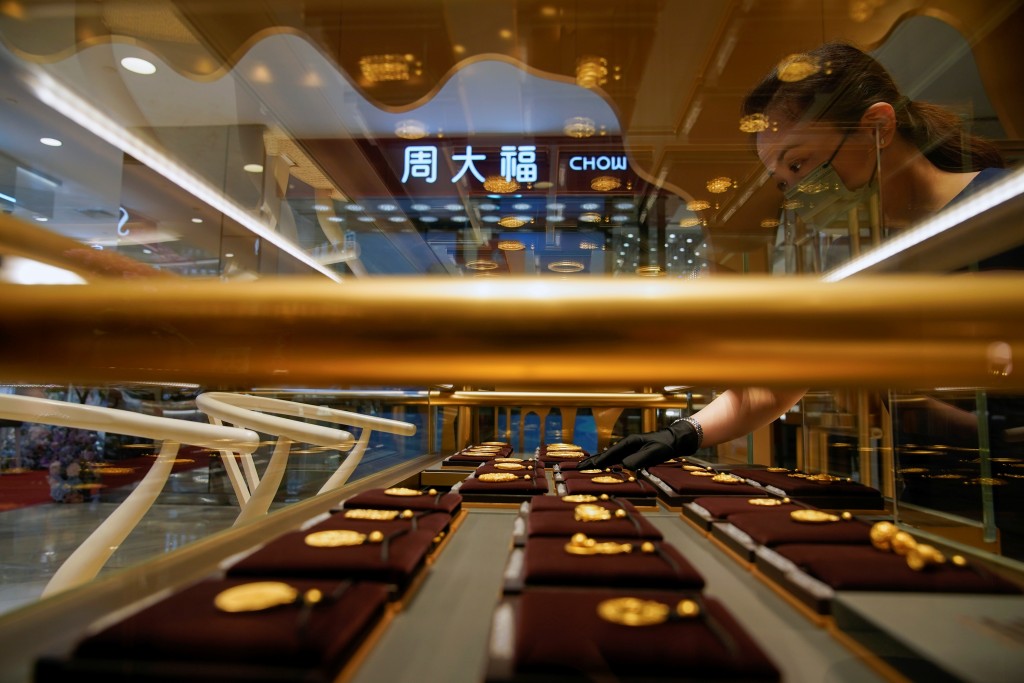 A salesperson poses with Heritage Gold jewellery at jeweller Chow Tai Fook retail store in Shanghai, China August 18, 2021. Picture taken August 18, 2021. REUTERS