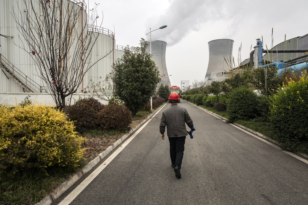 A worker walks past storage tanks for industrial mixed oil at the Jinshang facility in Chengdu. (Bloomberg)