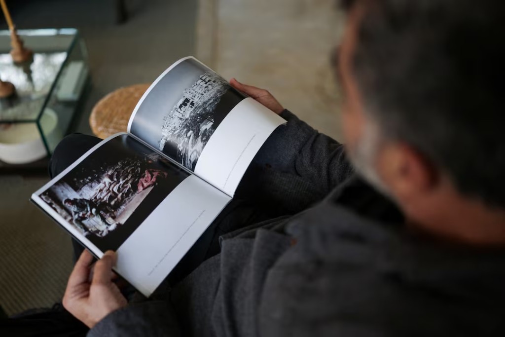  Lebanese photographer Patrick Baz holds a photography book with pictures he took during the Lebanese civil war, in his home in Batroun, Lebanon, April 8, 2026. REUTERS/Emilie Madi 